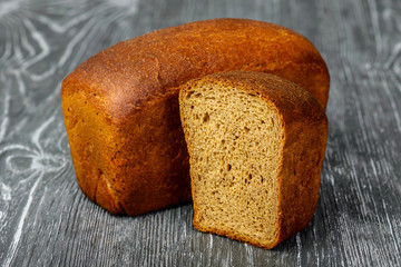 Bread of rye flour in a cut on a gray wooden background
