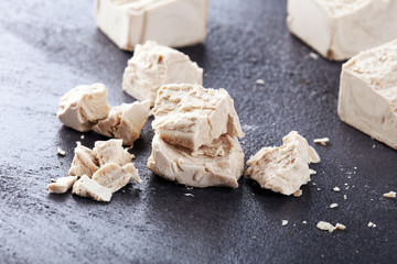 Dry yeast crumbled and yeast block for baking on background