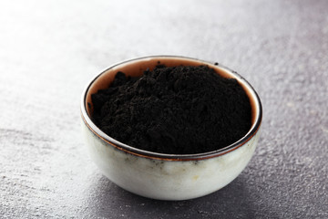 Activated charcoal powder. Black charcoal powder on table