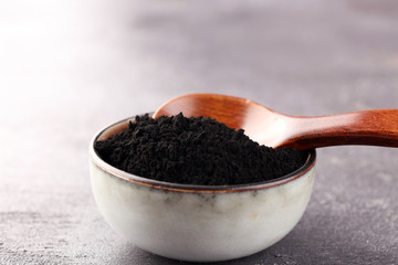 Activated charcoal powder. Black charcoal powder on table