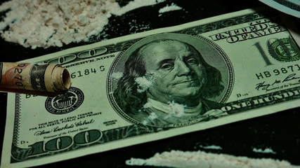 drugs and money. drug addiction. Twisted banknote through which sniffing cocaine. A hundred dollars...
