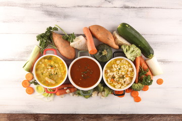 Set of soups from worldwide cuisines, healthy food. Broth with noodles, beef soup and broth with marrow dumplings. All soups with healthy vegetables on table