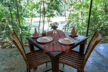 Served table and rattan chairs in an empty restaurant terrace. Tanzania, Africa