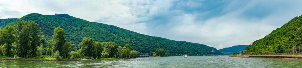 Naklejka na ściany i meble Germany, Rhine Romantic Cruise, a large body of water with a mountain in the background panorama