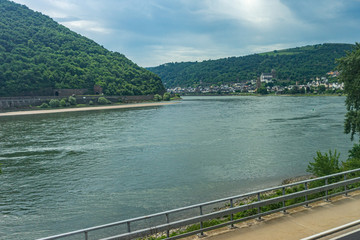 Fototapeta na wymiar Germany, Rhine Romantic Cruise, a train traveling down train tracks next to a body of water