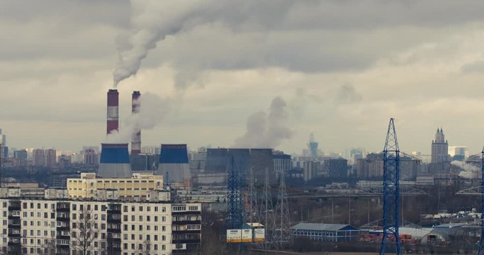 Red camera telephoto lens time lapse of curling clouds and smoking stacks of a depressive industrial urban area. Moscow, Russia
