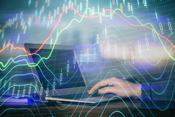 Double exposure of stock market graph with man working on laptop on background. Concept of financial analysis.