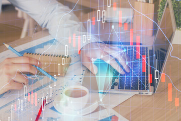 Forex graph with businessman working on computer in office on background. Concept of hardworking....