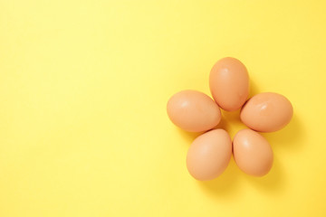 黄色い背景に五個花形に並んだ卵