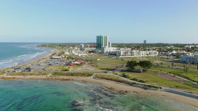 Dramatic aerial dolly zoom approaching Pollok Beach in Port Elizabeth. Sickening push pull effect in flight