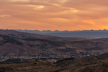 Fototapeta na wymiar Cityscape view of Esquel against Andes range during colorful sunset in Patagonia, Argentina