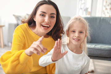 Young woman and her little daughter video chatting at home