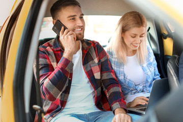 Portrait of young couple sitting in taxi