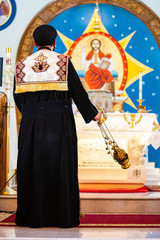 Priest performing church ceremony with Thurible christian accessory