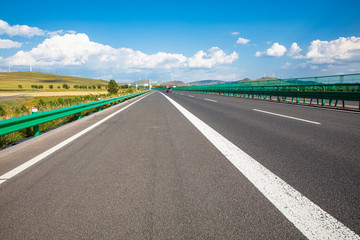 Fototapeta premium Empty highway, blue sky and white clouds landscape