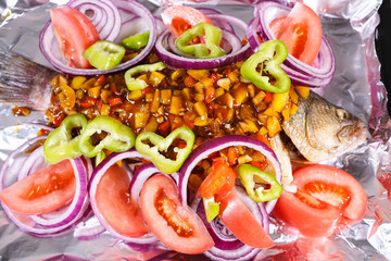 Vegetables and bass on the chopping board