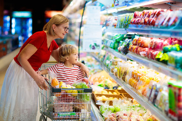 Mother and child buying fruit in supermarket.