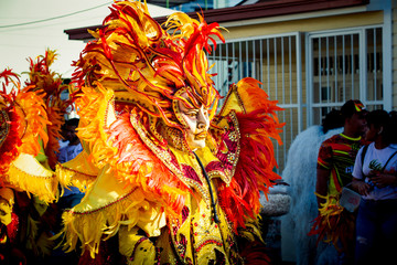 closeup man in glossy masquerade costume passes by city street at dominican carnival