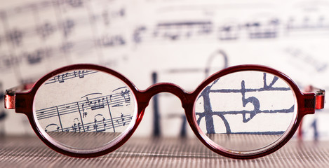 Red Vintage Eyeglasses Glasses smudged view agaist a musica Note sheet. Blurry Vision Concept