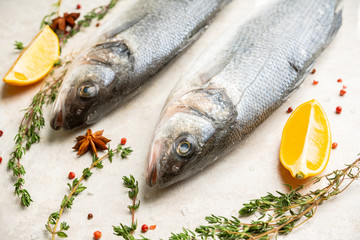 Raw whole seabass fish on the rustic background. Selective focus. Shallow depth of field.