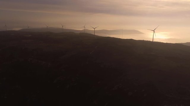 Aerial scene of Wind turbines rotating during sunset