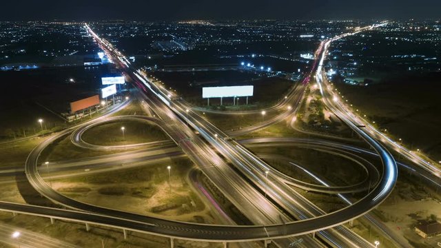 timelapse of night city traffic on 4-way stop street intersection circle roundabout in bangkok, thailand. 4K UHD horizontal aerial view.