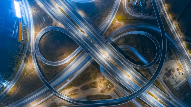 Hyperlapse timelapse of night city traffic on 4-way stop street intersection circle roundabout in bangkok, thailand. 4K UHD horizontal aerial view.