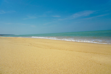 Golden sand beach has sand, sea water, sand, the sea water on the sand.
