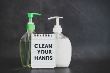 keep clean to fight bacteria and viruses, hand sanitizer and liquid soap next to memo with Clean your Hands text