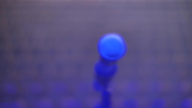 Microphone on stage against blurred auditorium background, selective focus