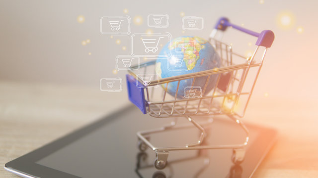 A globe and tablet in the shopping trolley global market concept.