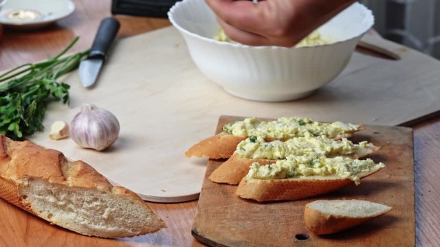 woman is cooking Jewish salad of grated cheese, eggs and garlic spread on a slice of bread