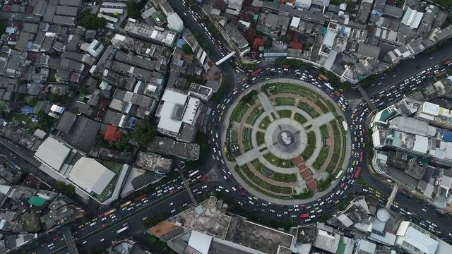 Hyperlapse timelapse moving go right circular of night city traffic on 4-way stop street intersection circle roundabout in bangkok, 4K UHD horizontal aerial view.