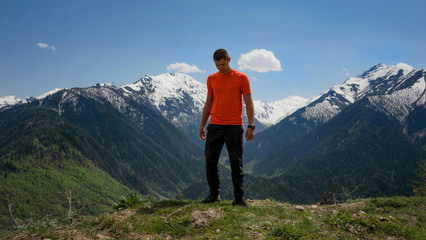 The guy in the orange shirt in the background of mountains