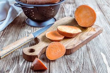 Organic farm sweet potato on rustic wooden background. Healthy eating and zero waste concept....