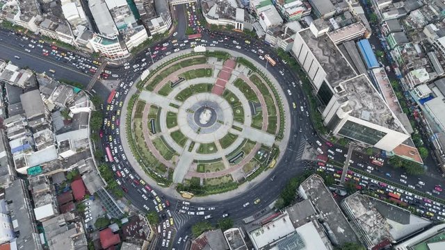 Hyperlapse timelapse moving go right circular of night city traffic on 4-way stop street intersection circle roundabout in bangkok, 4K UHD horizontal aerial view.