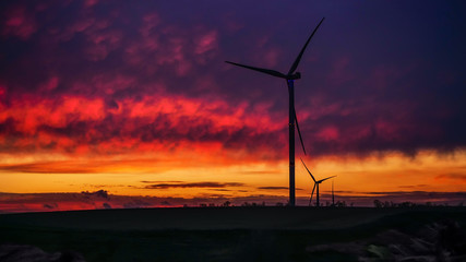 Obraz premium Wind generator triple set on scenic sundown