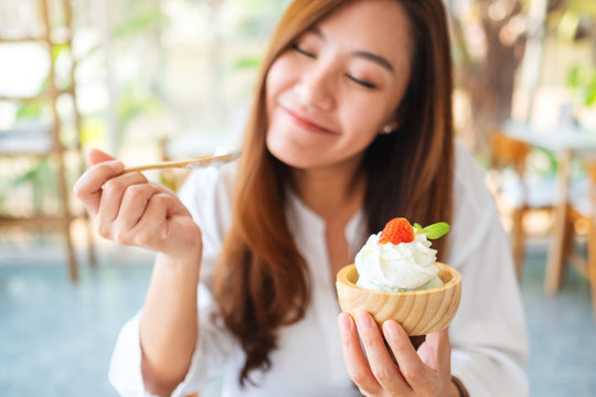 Closeup image of a beautiful asian woman enjoy eating an ice cream in restaurant
