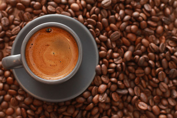 Closeup of espresso cup and dark roasted beans. Coffee shop, top view, espresso, fresh roast, drink, crop  concept