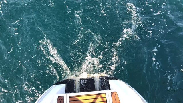 White Sailing Catamaran Yacht walking near Jeju island. Surf, waves and rocks from yacht boat.