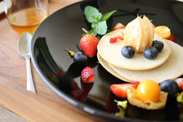 Organic pancake topping with honey, berry and fruit healthy food.