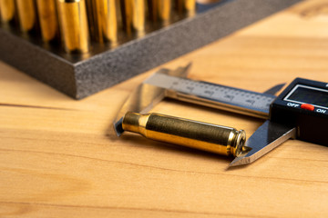 Production of cartridges for a rifle, reload. Measurement of the empty cartridges with a caliper. Close up