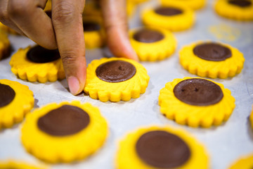 Close up of female hands making cookies from fresh dough at home