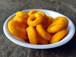 SOME YELLOW EATABLE FOOD PUT IN A BOWL ON STONE BACKGROUND