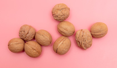 Walnuts on a pink background.