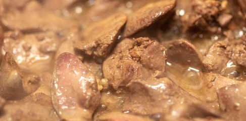 Chicken liver is fried in a pan.