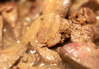 Chicken liver is fried in a pan.