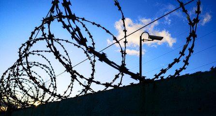 Barbed wire against the sky with clouds