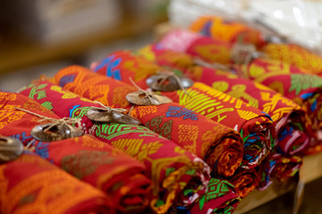 Fototapeta na wymiar Traditional woven fabrics of various colors are displayed in a way rolled to attract tourists.