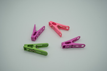 Many colored clothes pegs and many white backgrounds